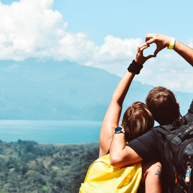 A couple in nature forming a heart shape with hands